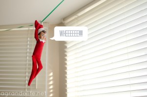Elf on the shelf ziplining on a string across the ceiling